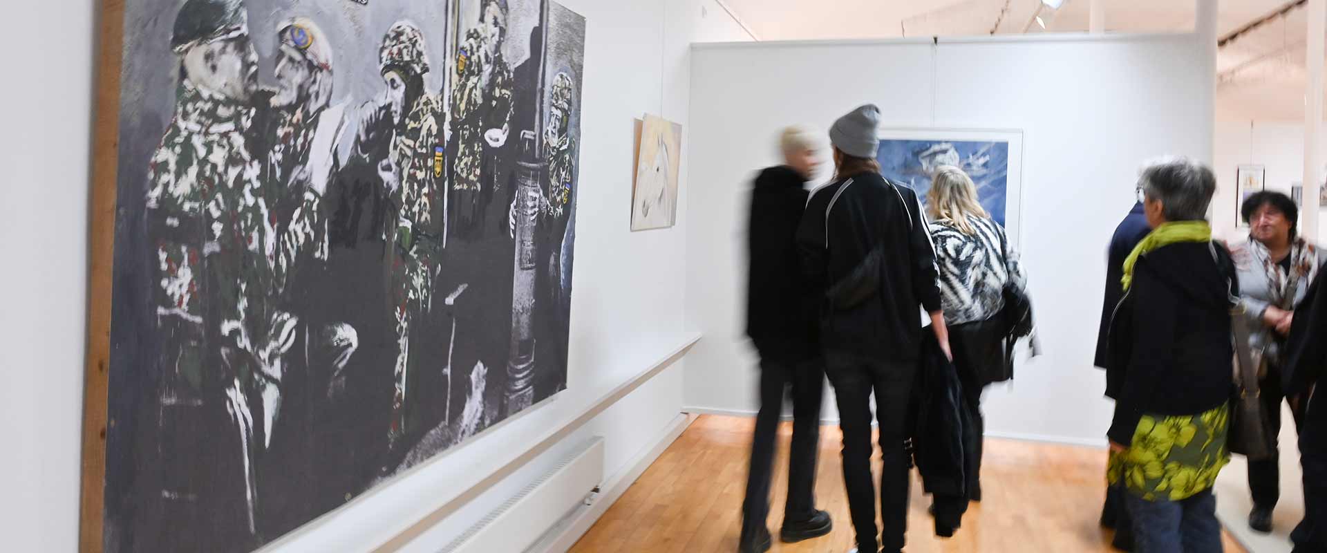 Besucherinnen und Besucher vor großformatigen Werken der Jahresausstellung